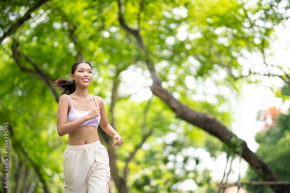 Portrait of Fit mildfulness young Asian woman jogging with smile at summer park. Fitness, sport and healthy lifestyle concept. Feel fresh air and nature. Portrait of Fit mildfulness young Asian woman jogging with smile at summer park. Fitness, sport and healthy lifestyle concept. Feel fresh air and nature.