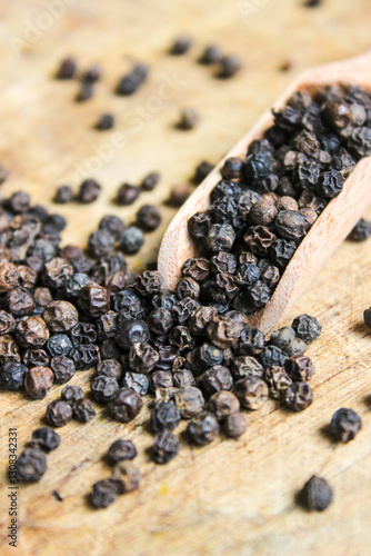 Fototapeta Naklejka Na Ścianę i Meble -  Black pepper on wooden spoon with wood background. Food ingredients. Aromatic spice
