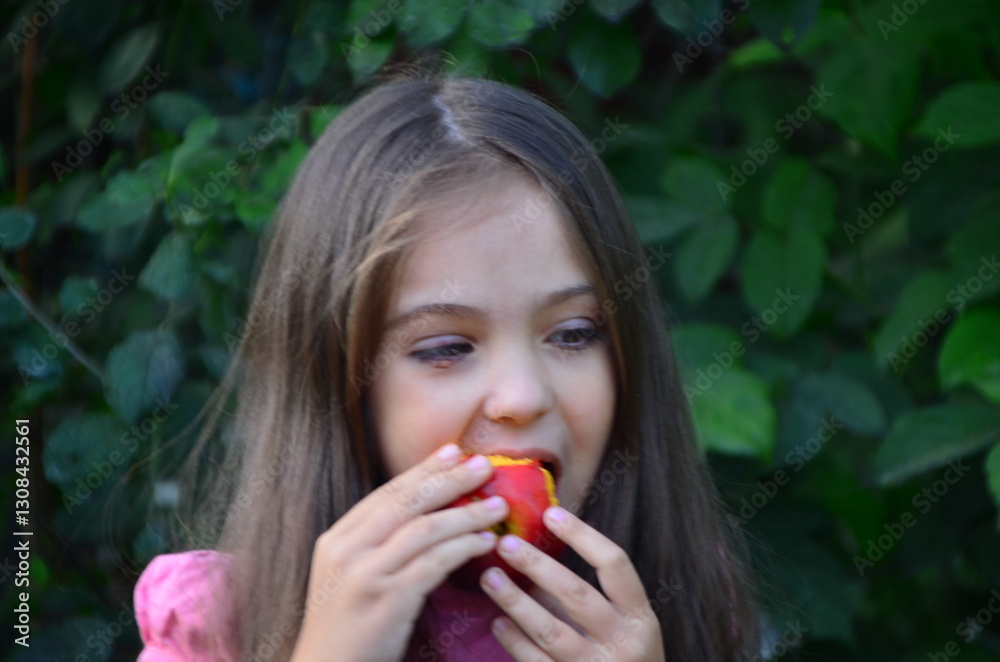 Happy young girl with long hair eat tasty juicy yellow peach. Kid sit near the table. Nice fresh healthy food for breakfast or dinner. She handle fruit gently and carefully with two hands. Happy young girl with long hair eat tasty juicy yellow peach. Kid sit near the table. Nice fresh healthy food for breakfast or dinner. She handle fruit gently and carefully with two hands.
