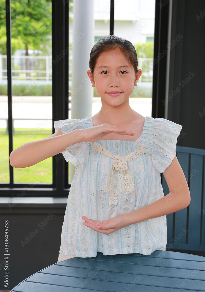 Asian young girl doing hands holding something blank while standing in door. Advertising, product and promotion ideas concept.