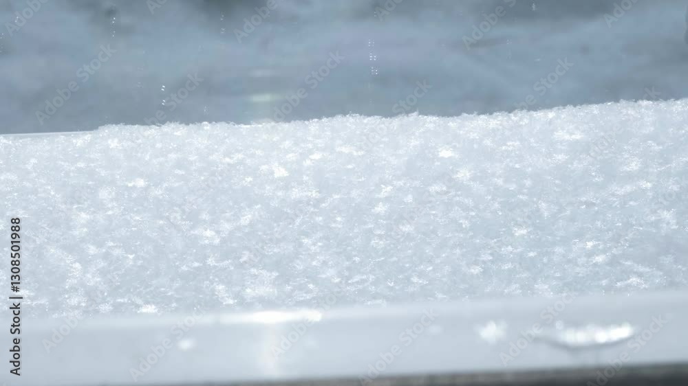 Layer of white snow lying on the windowsill in sunny winter weather. View from window close-up. Layer of white snow lying on the windowsill in sunny winter weather. View from window close-up.