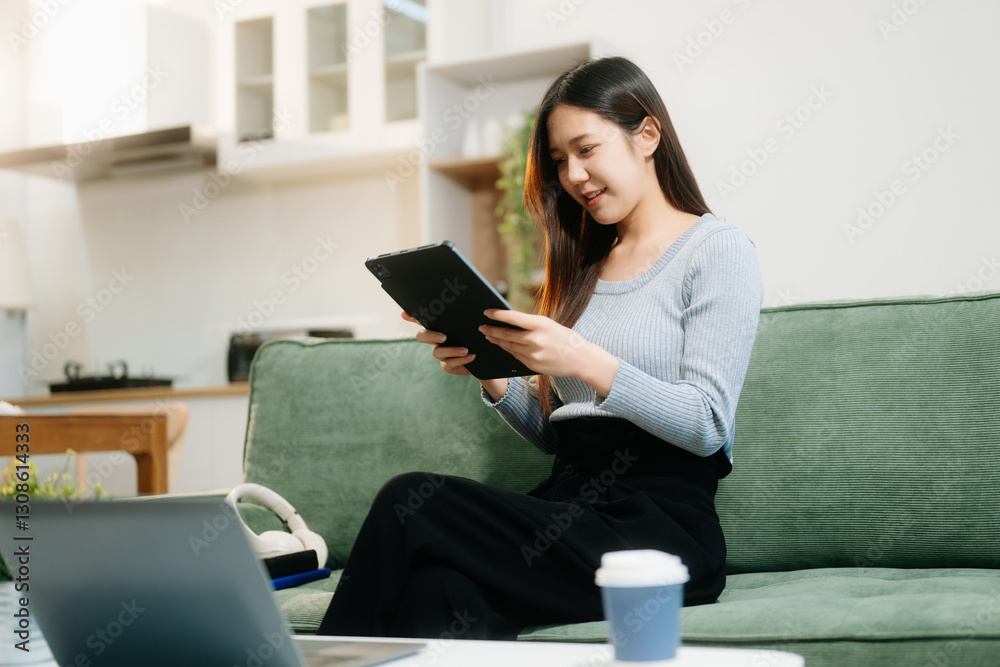 Asian woman using the smartphone and tablet on the sofa at home. Asian woman using the smartphone and tablet on the sofa at home.