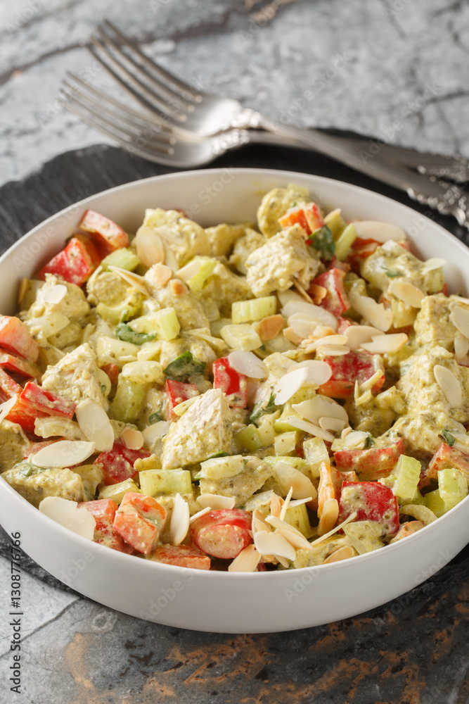 Pesto Chicken Salad with celery, onion, pepper and almond flakes closeup on the table. Vertical