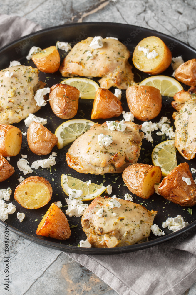 Sheet Pan Lemon Feta Chicken with baked potatoes closeup on the table. Vertical