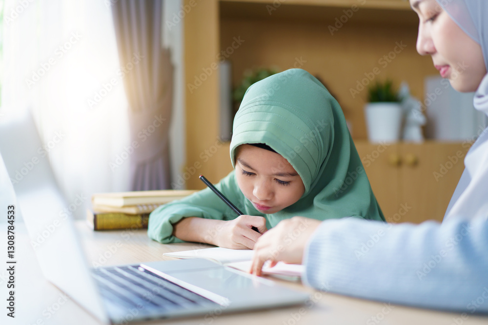 Asian muslim woman is teaching and reviewing homework with her daughter. Asian muslim woman is teaching and reviewing homework with her daughter.