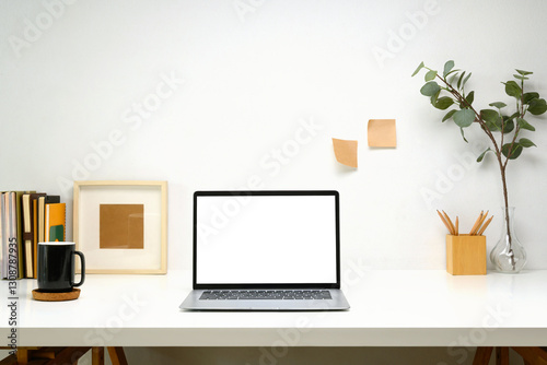 Laptop with blank screen, planner and a white coffee mug on white table, minimalist and modern workspace photo