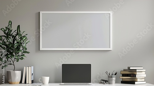 A white rectangular frame above a home office desk with a laptop, a cup, and a few books stacked next to it.  HD 8K white mockup wallpaper Photographic Image
