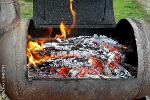 Burning embers while preparing the barbeque grill fire