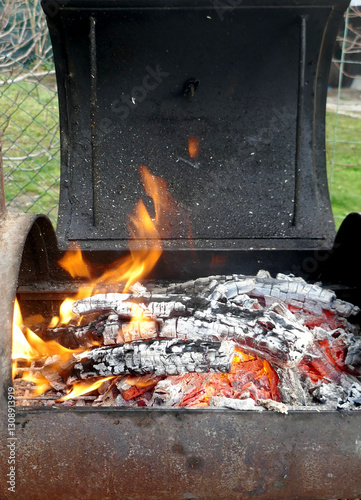 Burning embers while preparing the barbeque grill fire