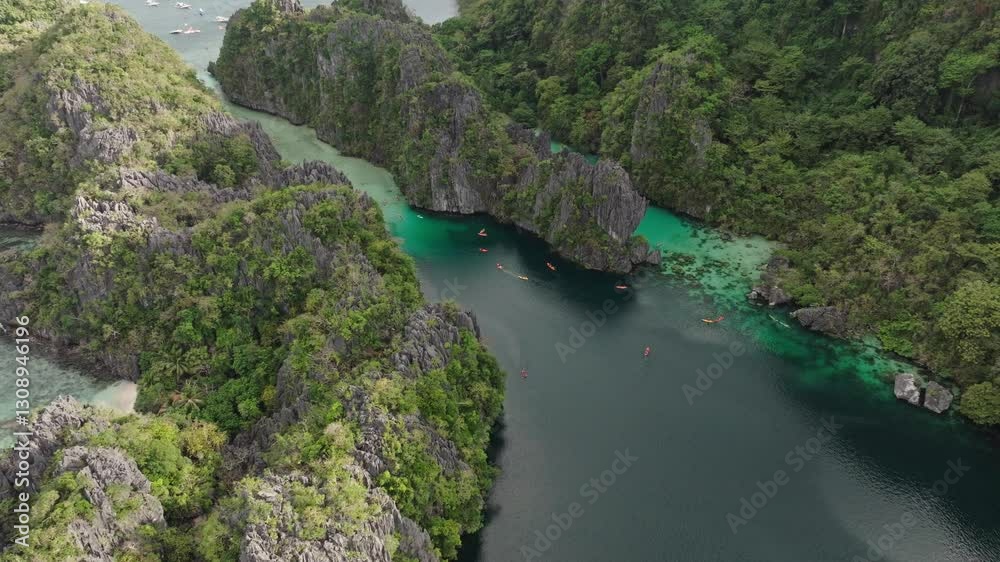 Drone view of Big Lagoon and Small Lagoon in El Nido, Palawan, featuring crystal-clear water surrounded by towering limestone cliffs. Drone view of Big Lagoon and Small Lagoon in El Nido, Palawan, featuring crystal-clear water surrounded by towering limestone cliffs.
