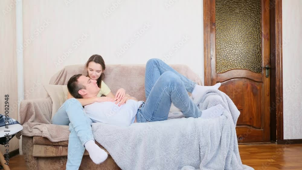 Young couple relaxing on couch in living room at home Young couple relaxing on couch in living room at home