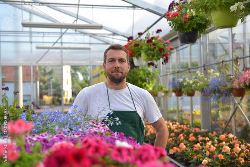 happy worker growing flowers in a greenhouse of a flower shop