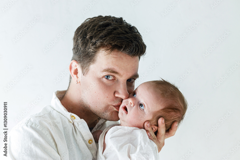 Happy Fathers day! Stylish father kissing and hugging little baby son close up against white wall. Fatherhood and parenthood. Adoption and fertility concept Happy Fathers day! Stylish father kissing and hugging little baby son close up against white wall. Fatherhood and parenthood. Adoption and fertility concept