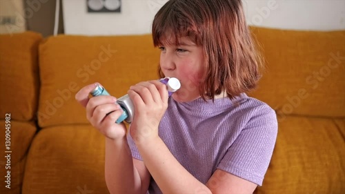 Child using asthma inhaler with determination on a cozy couch