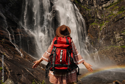 An Adventurous Hiker Standing at a Beautiful and Majestic Waterfall in Natures Splendor