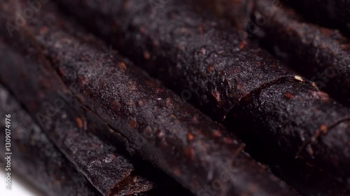 Textures of homemade organic fruit pastille mix rotating around. Homemade healthy snack concept. Tklapi. Fruit pastille. Colorful fruit peel rolls on crushed fruit mats.