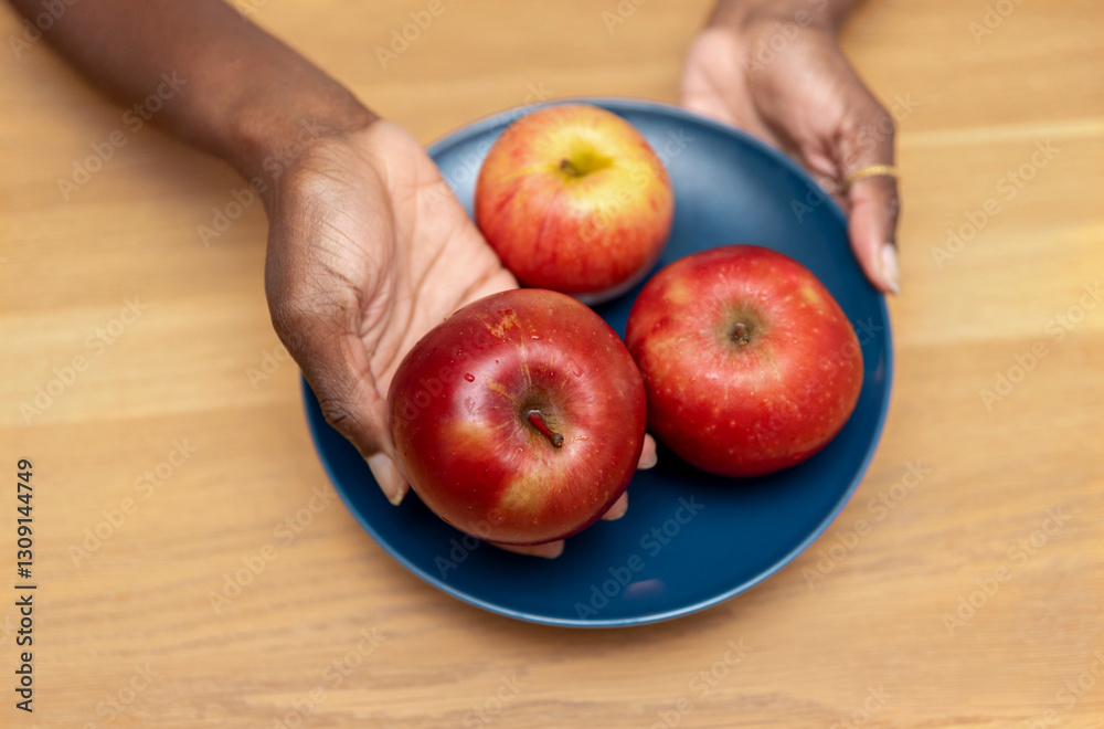 custom made wallpaper toronto digitaltop view of a Woman's hands Presenting Three Apples on a Blue Plate on wooden background