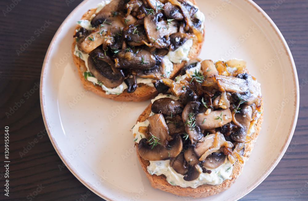 delicious mushroom toast with herb cream cheese, mushrooms, and caramelized onions on a white modern plate close-up delicious mushroom toast with herb cream cheese, mushrooms, and caramelized onions on a white modern plate close-up