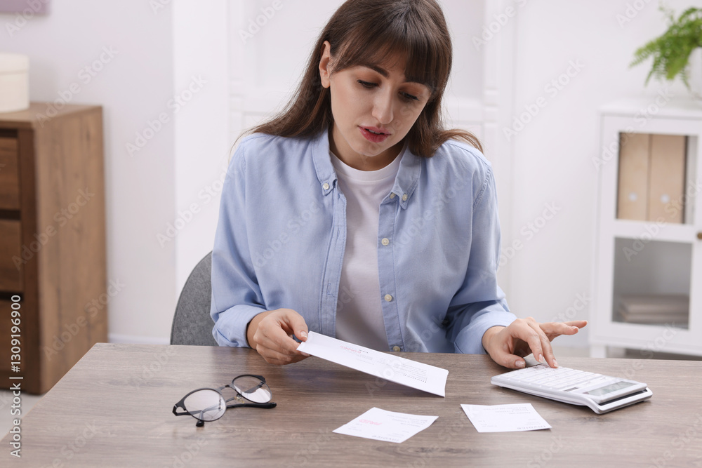 Paying bills. Woman with different invoices and calculator at wooden table indoors Paying bills. Woman with different invoices and calculator at wooden table indoors