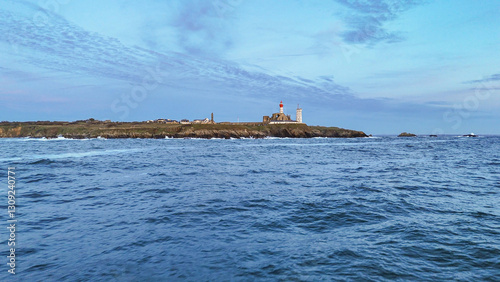 Photo du phare de la Pointe Saint-Mathieu en Bretagne, capturée de loin, depuis la mer, révélant son caractère emblématique et son paysage spectaculaire. photo