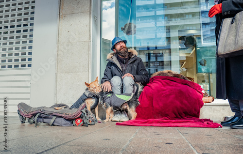 Homeless man with dogs sitting on sidewalk begging money
