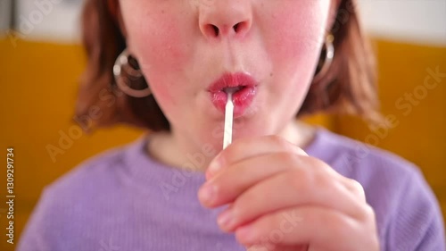 Child enjoying a tasty lollipop in a cozy indoor setting