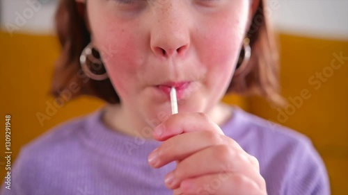 Child joyfully enjoying a lollipop on a sunny afternoon in the park