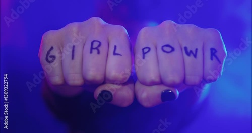 Feminist woman showing her knuckles with Girl Power written on them