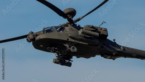 close-up of an overhead British army AH-64E AH64E AH2 Boeing Apache Attack helicopter gunship (ZM735 ArmyAirCorp) flying in a blue sky