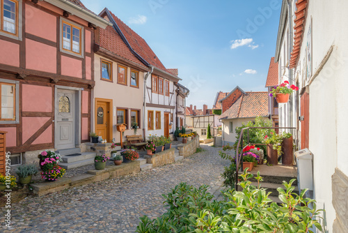 Fototapeta Naklejka Na Ścianę i Meble -  Quedlinburg, Germany – August 29, 2024: The streets of the Quedlinburg city district of the Münzenberg feature many picturesque half-timbered houses. It is also part of the UNESCO World Heritage.