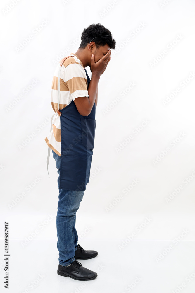 Naklejka premium Young handsome asian man wearing apron over isolated white background with sad expression covering face with hands while crying. Depression concept.