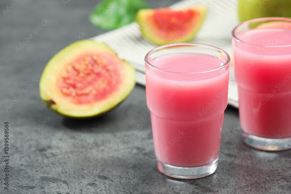 Refreshing guava juice and fresh fruits on grey table, closeup Refreshing guava juice and fresh fruits on grey table, closeup