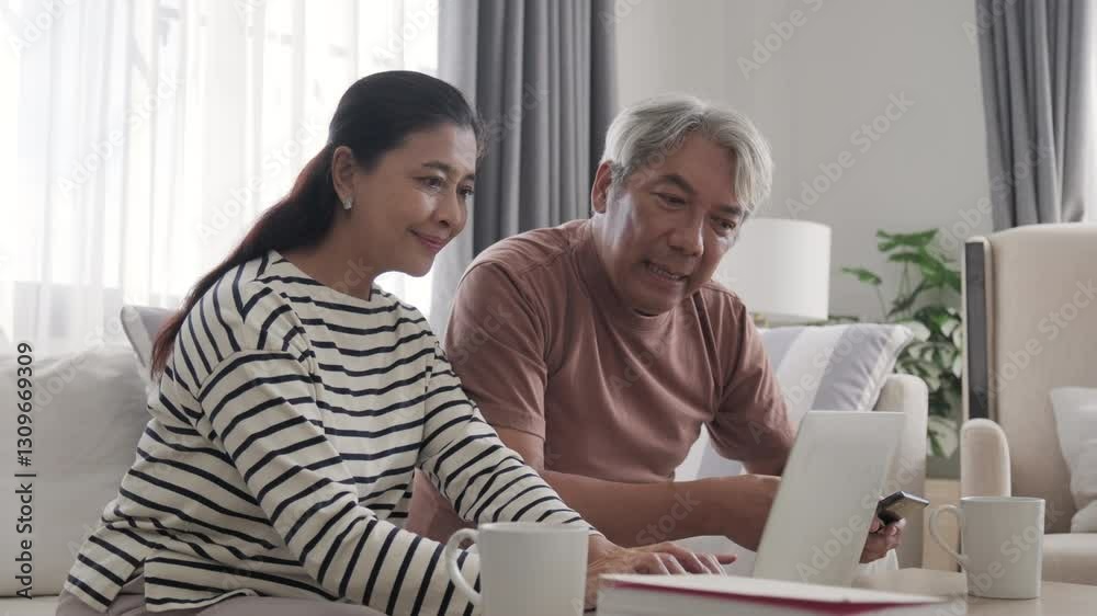 Senior Asian couple working with notebook at home. Senior Asian couple working with notebook at home.