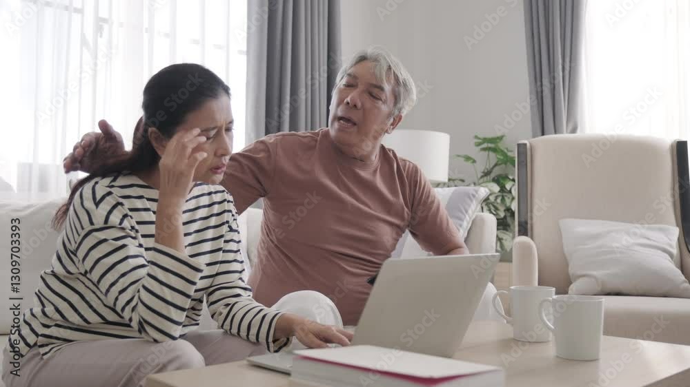 Senior Asian couple looking at notebook and feel disappointed Senior Asian couple looking at notebook and feel disappointed