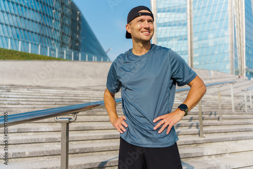 Runner pauses for breath in urban setting after a vigorous workout during sunny day