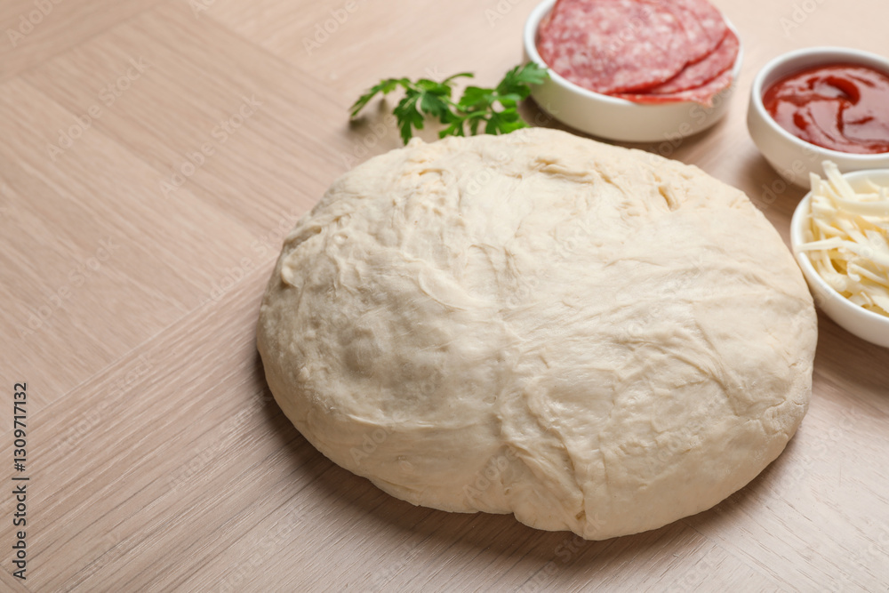 Making calzone pizza. Dough and ingredients on wooden table, closeup Making calzone pizza. Dough and ingredients on wooden table, closeup