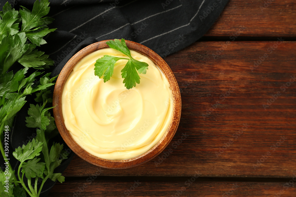 Fototapeta premium Delicious mayonnaise sauce with parsley in bowl on wooden table, top view. Space for text