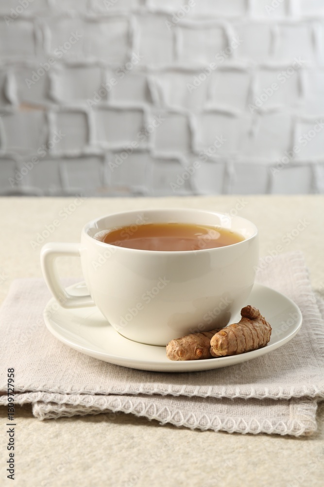 Aromatic turmeric tea and rhizomes on white textured table. Space for text Aromatic turmeric tea and rhizomes on white textured table. Space for text