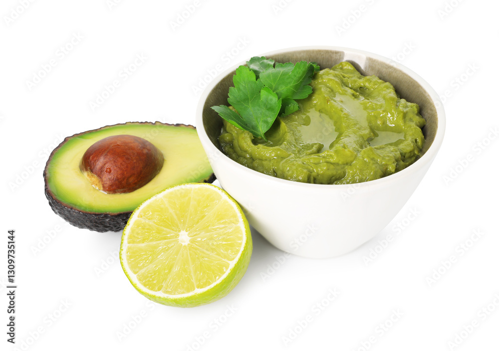 Tasty avocado dip in bowl, lime and parsley isolated on white Tasty avocado dip in bowl, lime and parsley isolated on white