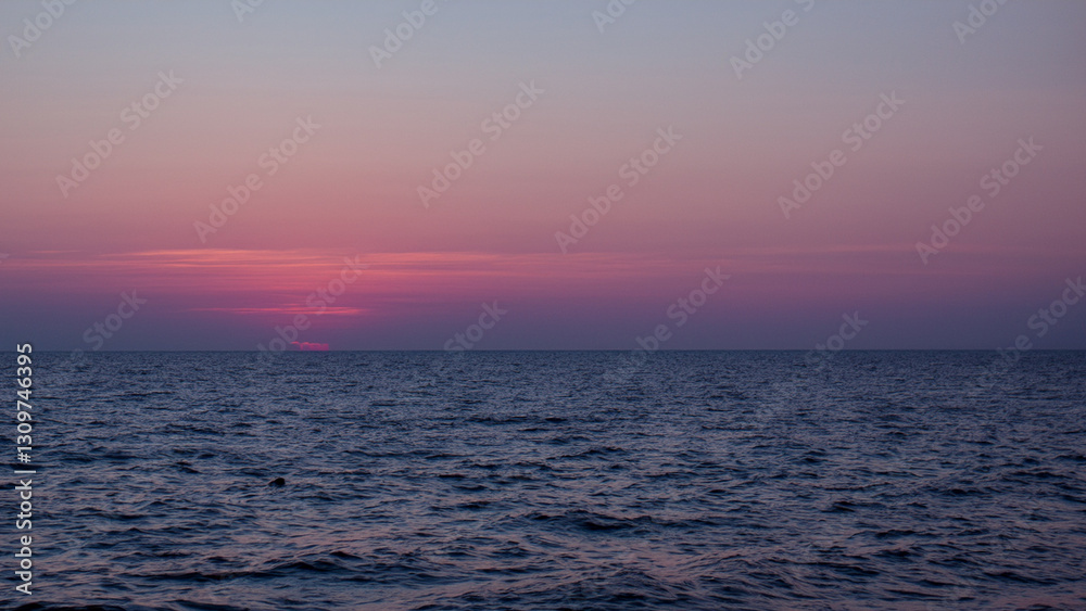 Obraz premium ピンク色の夕焼けと水平線と海