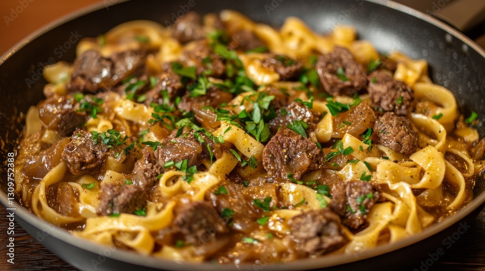 A sizzling pan of delicious linguine pasta with tender, browned pieces of meat, caramelized onions, and a rich, savory tomato-based sauce A sizzling pan of delicious linguine pasta with tender, browned pieces of meat, caramelized onions, and a rich, savory tomato-based sauce