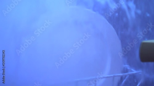 Blue-tinted dishwasher macro: water jets clean plate through glass door. HD close-up highlights efficiency. Ideal for appliance ads, eco-tech content, loopable projects. No logos, neutral backdrop.