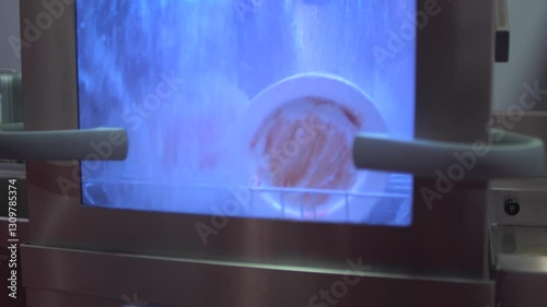 Transparent dishwasher in action: water jets clean dishes through glass door. HD close-up highlights efficiency. Ideal for ads, tech demos, eco-content, or kitchen brands. Neutral backdrop, loopable