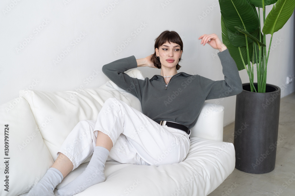 young beautiful woman sitting in a chair in the studio in a sweater young beautiful woman sitting in a chair in the studio in a sweater