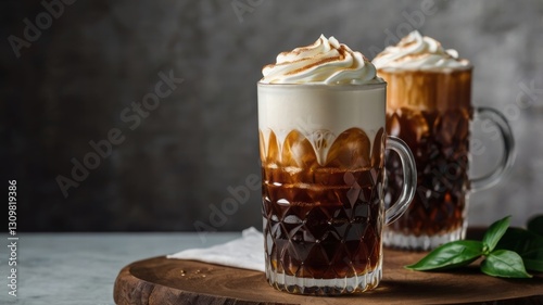 Two glasses of iced coffee with vanilla cold foam served on a table in a refreshing and inviting presentation
