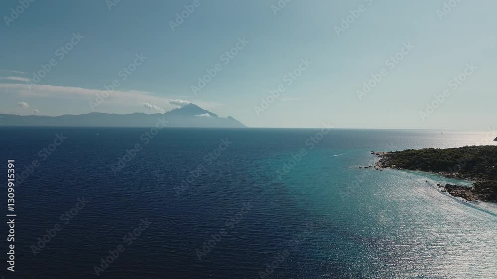 Experience the serene beauty of Mount Athos rising above the turquoise waters of the Mediterranean. This stunning landscape captures the essence of a summer day in Greece. Experience the serene beauty of Mount Athos rising above the turquoise waters of the Mediterranean. This stunning landscape captures the essence of a summer day in Greece.