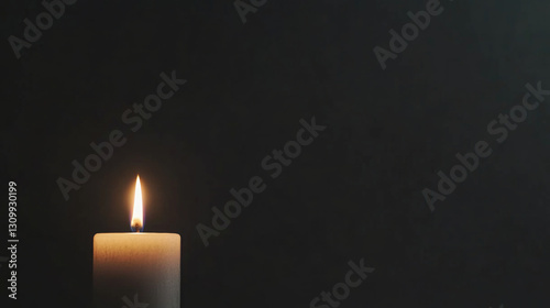 Candle flame illuminating darkness in a moment of mourning and remembrance