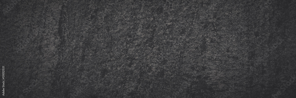 Fototapeta premium Dark gray granite texture. Natural granite with a grainy pattern. Solid rough surface of rock with spots, noise and grain. Dark stone background for design. Shaded texture with vignette.