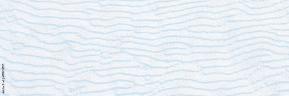 Wide panoramic winter background with snowy ground. Natural snow texture. Wind sculpted patterns on snow surface. Wide panoramic winter background with snowy ground. Natural snow texture. Wind sculpted patterns on snow surface.