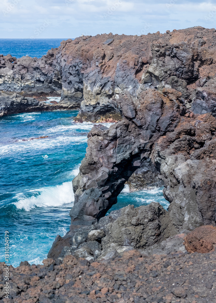 Majestic Ocean Waves Crash Against Volcanic Rock Formations